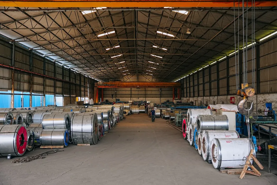 Inside the HST Steels facility — rows of steel coils and processing lines in Hyderabad